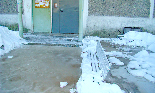 В результате последнего порыва вода вплотную подступила к четырем подъездам дома, превратившись впоследствии в лед 